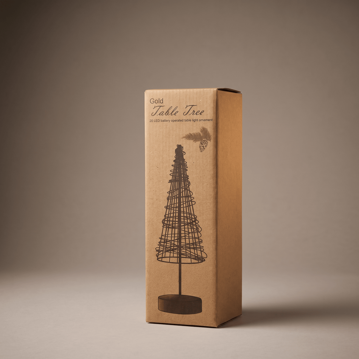 A tall rectangular cardboard box for a gold table tree, shown standing upright on a neutral warm gray studio background. The box is kraft brown with a printed black line drawing of the tree and the words 'Gold Table Tree' near the top.