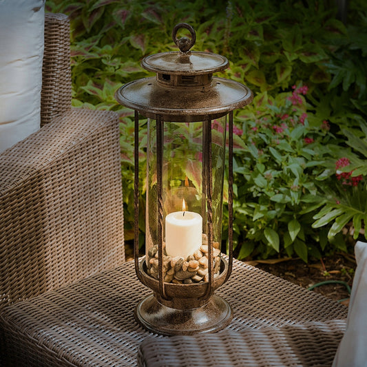 H Potter cast iron hurricane lantern with clear glass and a lit candle, styled on outdoor patio furniture for garden or porch décor.