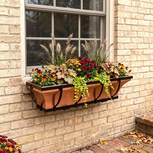 h potter brandl window box planter with black brackets mounted on a beige brick wall, filled with colorful fall flowers and ornamental grasses.