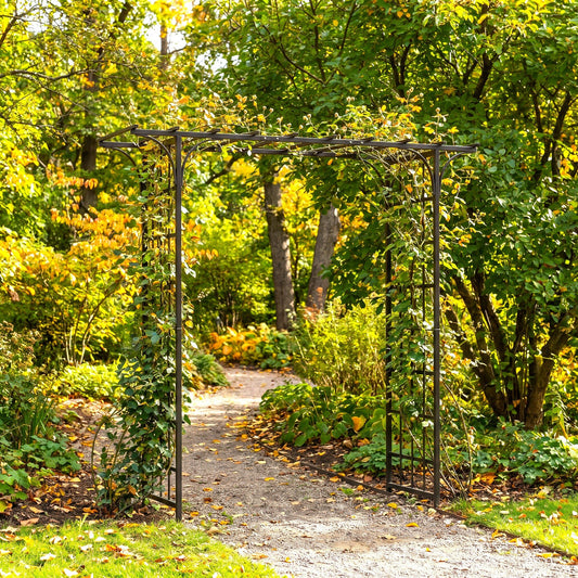h potter brand black metal garden archway with climbing trellis supports stands over a gravel path in a lush green garden with autumn foliage.
