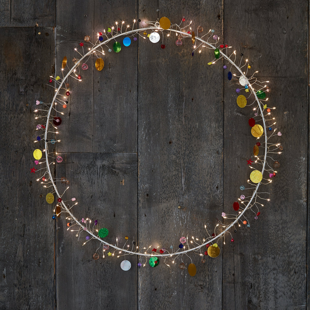 Detail of the Enchanted Jewel wreath's wire sprays, tiny warm LEDs beside red, blue and gold beads
