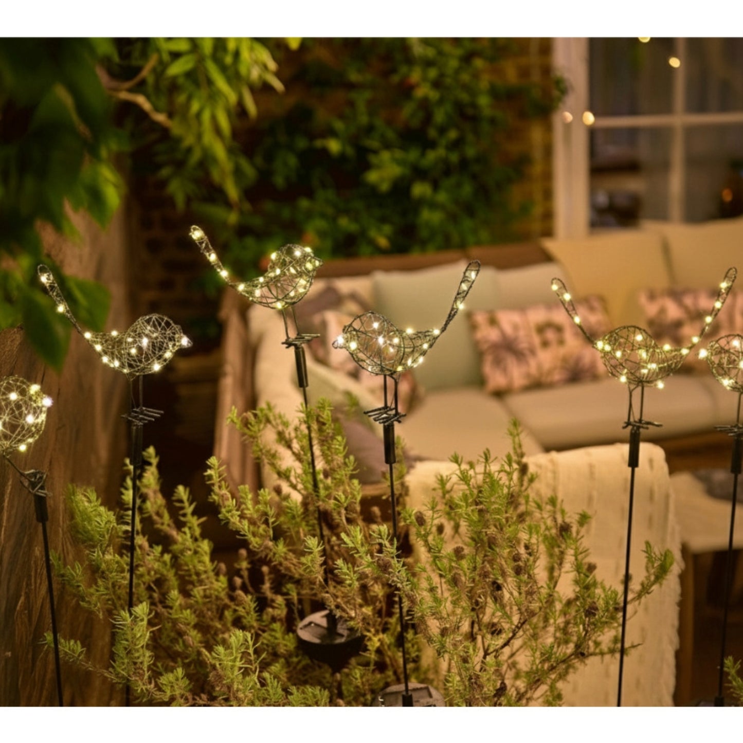 h potter metal solar sparrows staked in pots on a patio