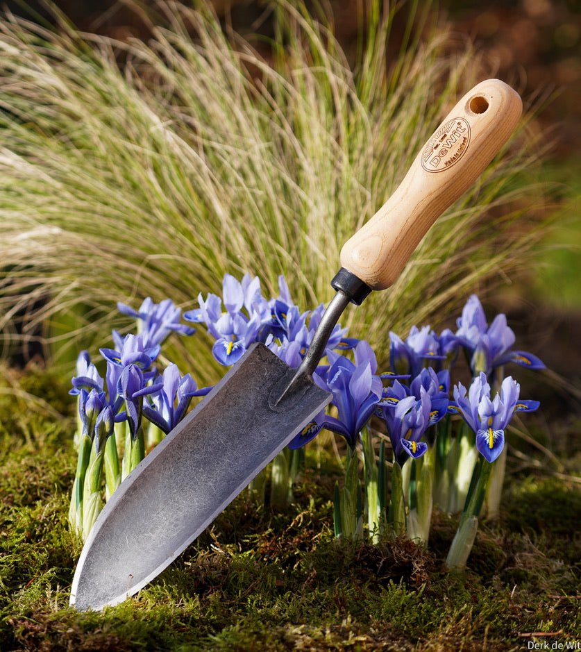 gardening trowel with long handle in a garden scene