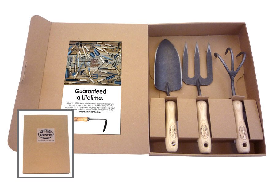 set of gardening tools trowel, fork, and cultivator in a cardboard box