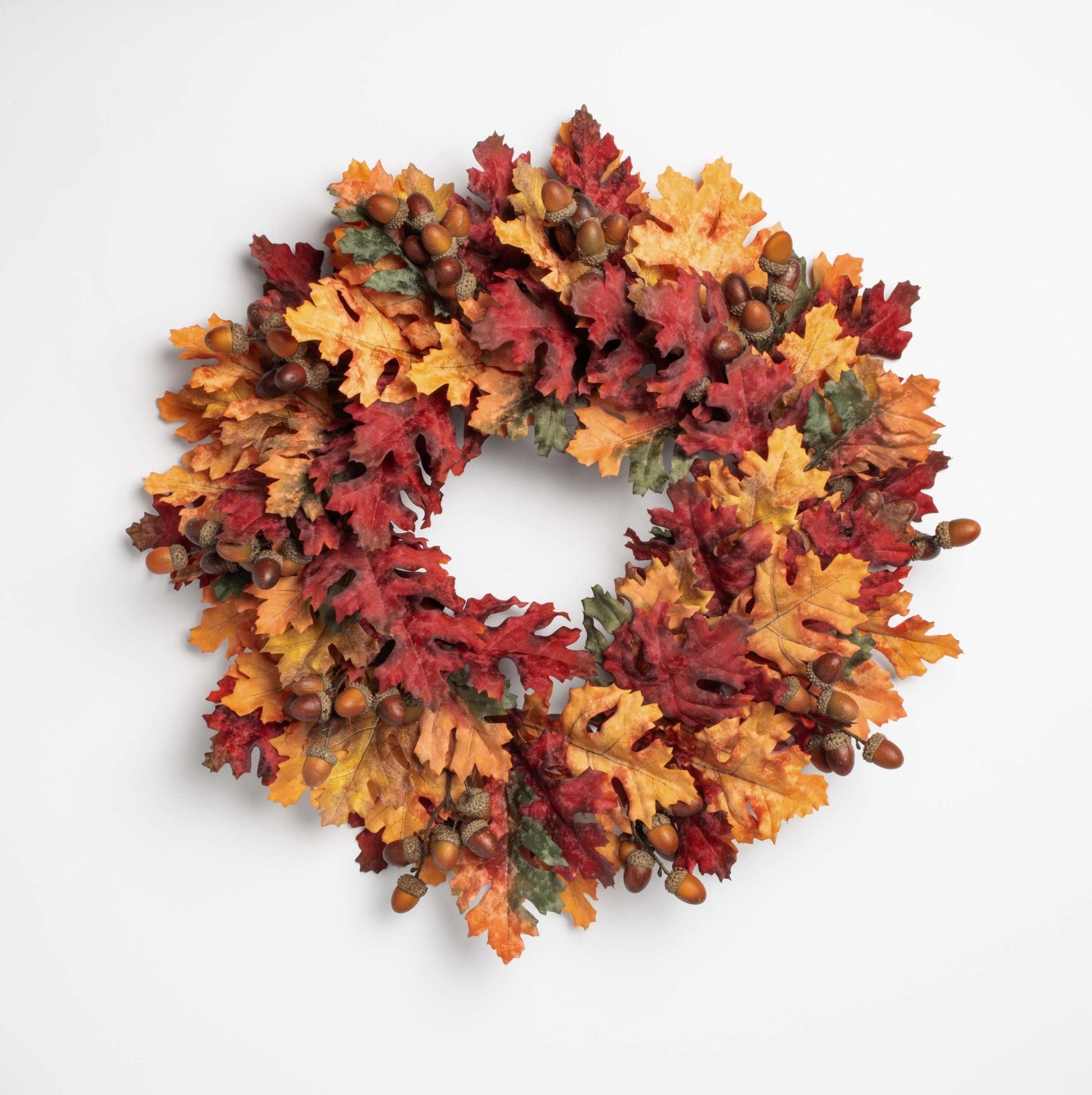 Autumn-themed wreath with leaves and acorns on a white background