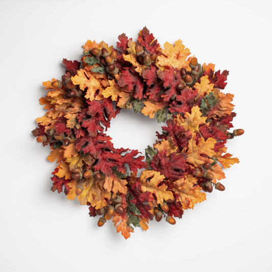 Autumn-themed wreath with leaves and acorns on a white background
