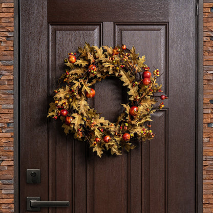 Decorative wreath with autumnal elements on a wooden door.