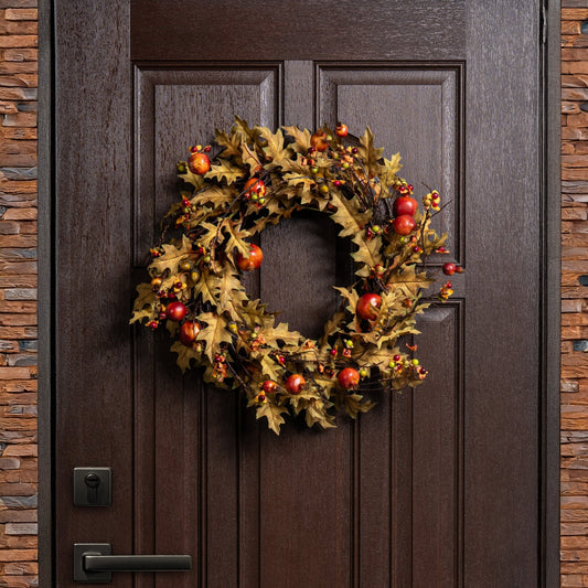 Decorative wreath with autumnal elements on a wooden door.