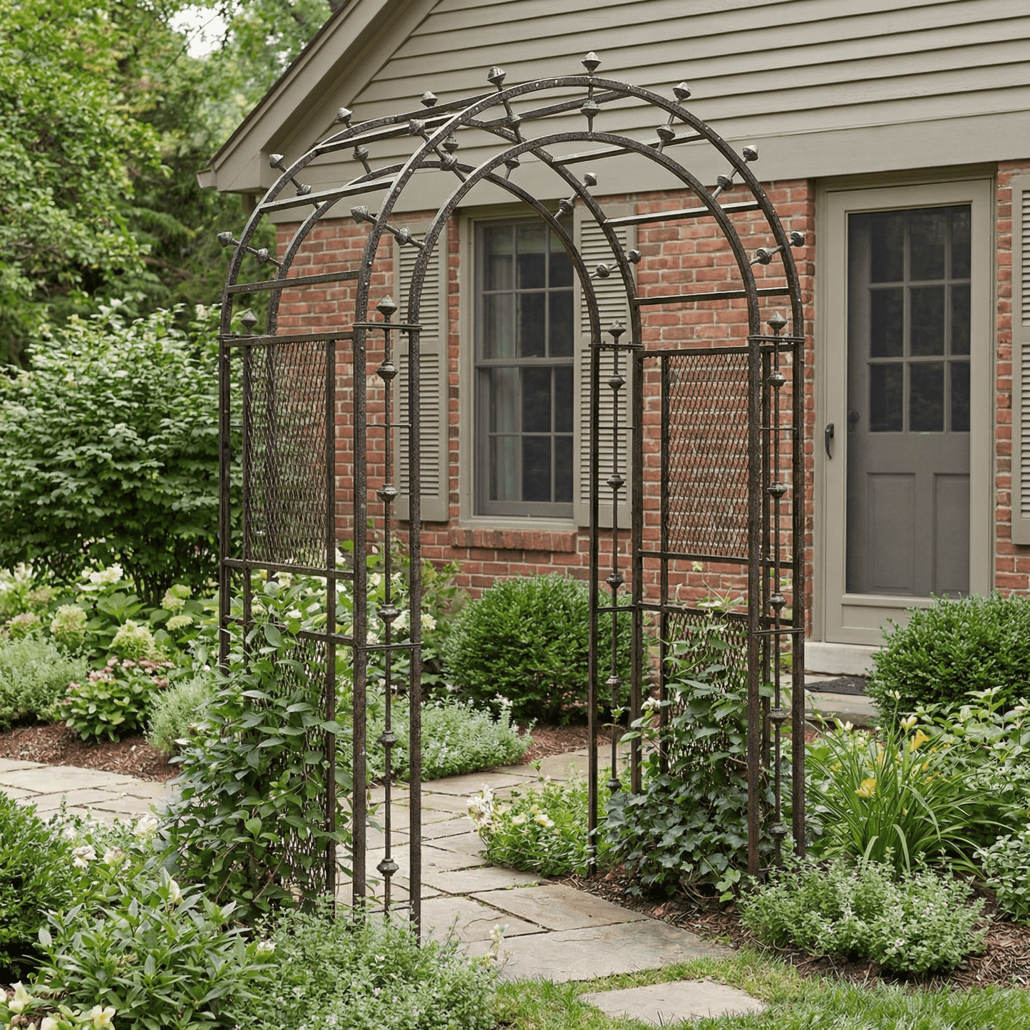 Decorative metal garden archway in a garden setting with a house in the background