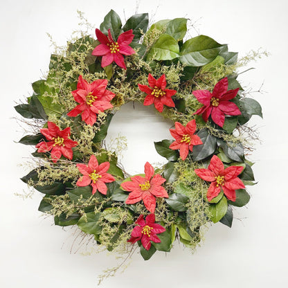 Christmas wreath with poinsettia flowers and green leaves on white background