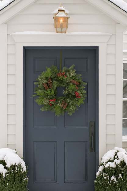 festive christmas wreath with red berries and pinecones on a front door 