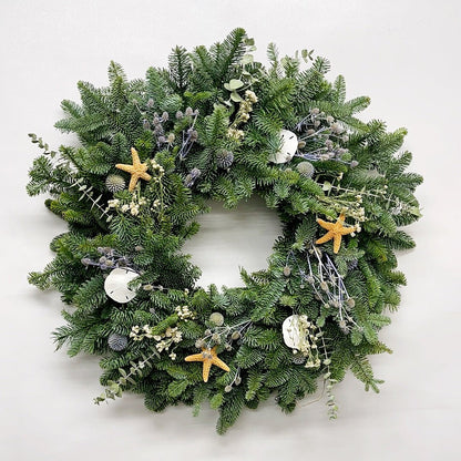 Decorative Christmas Wreath with seashells and starfish on a white background