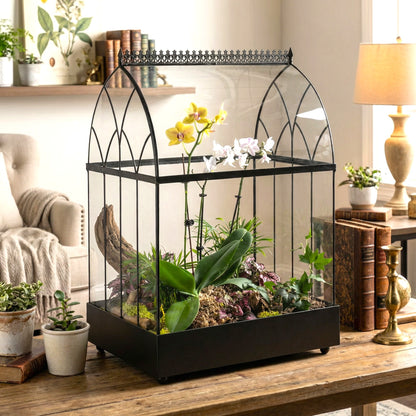 Glass terrarium with plants on a wooden table in a home setting