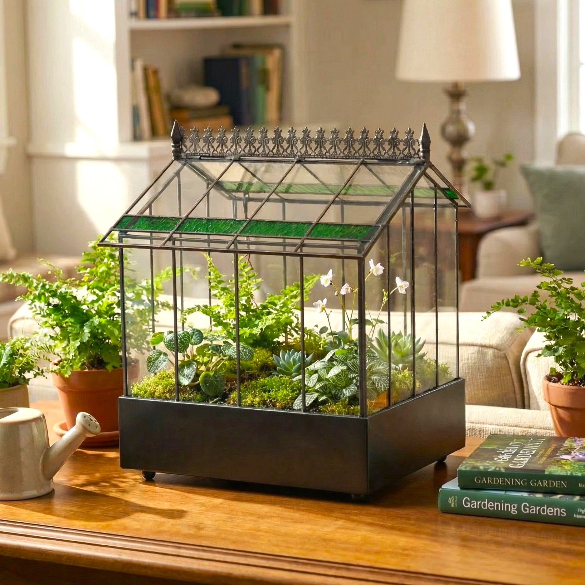Small glass greenhouse with plants on a wooden table in a home setting