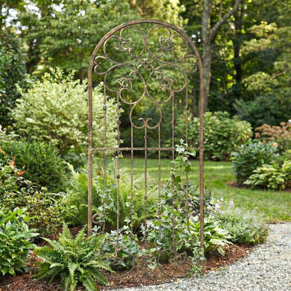Decorative metal garden archway in a lush garden setting