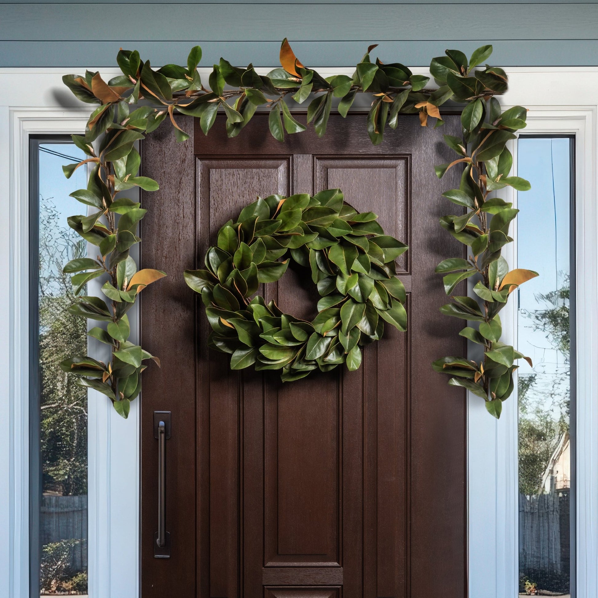 Decorative green wreath and garland on a brown door with glass panels.