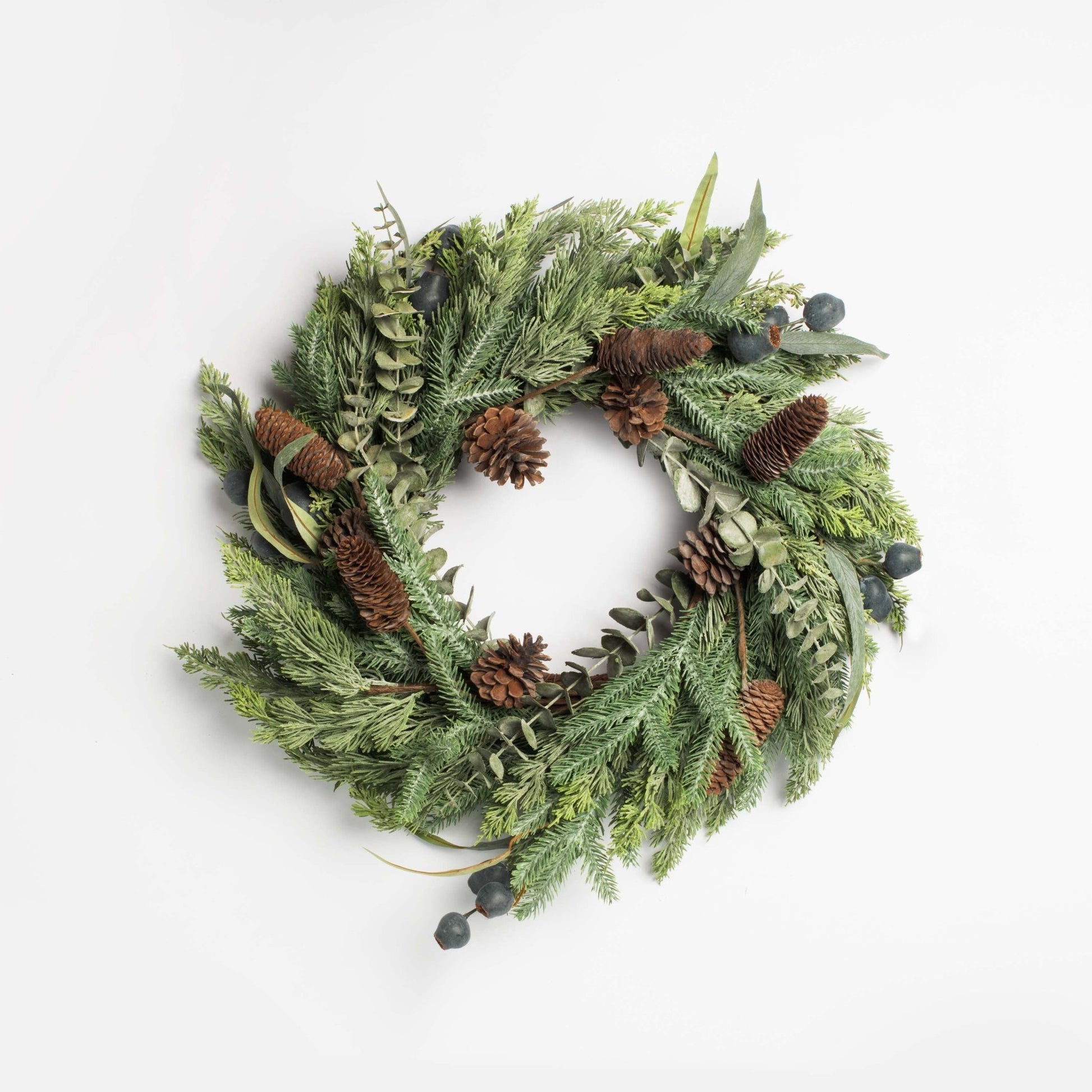 Green christmas  wreath with pinecones and berries on a white background