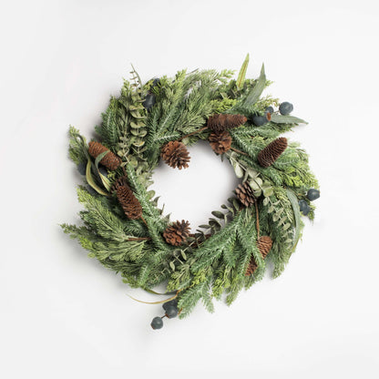 Green christmas  wreath with pinecones and berries on a white background
