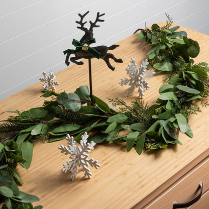 decorative holiday wreath with pine and eucalyptus on a cabinet with christmas decor