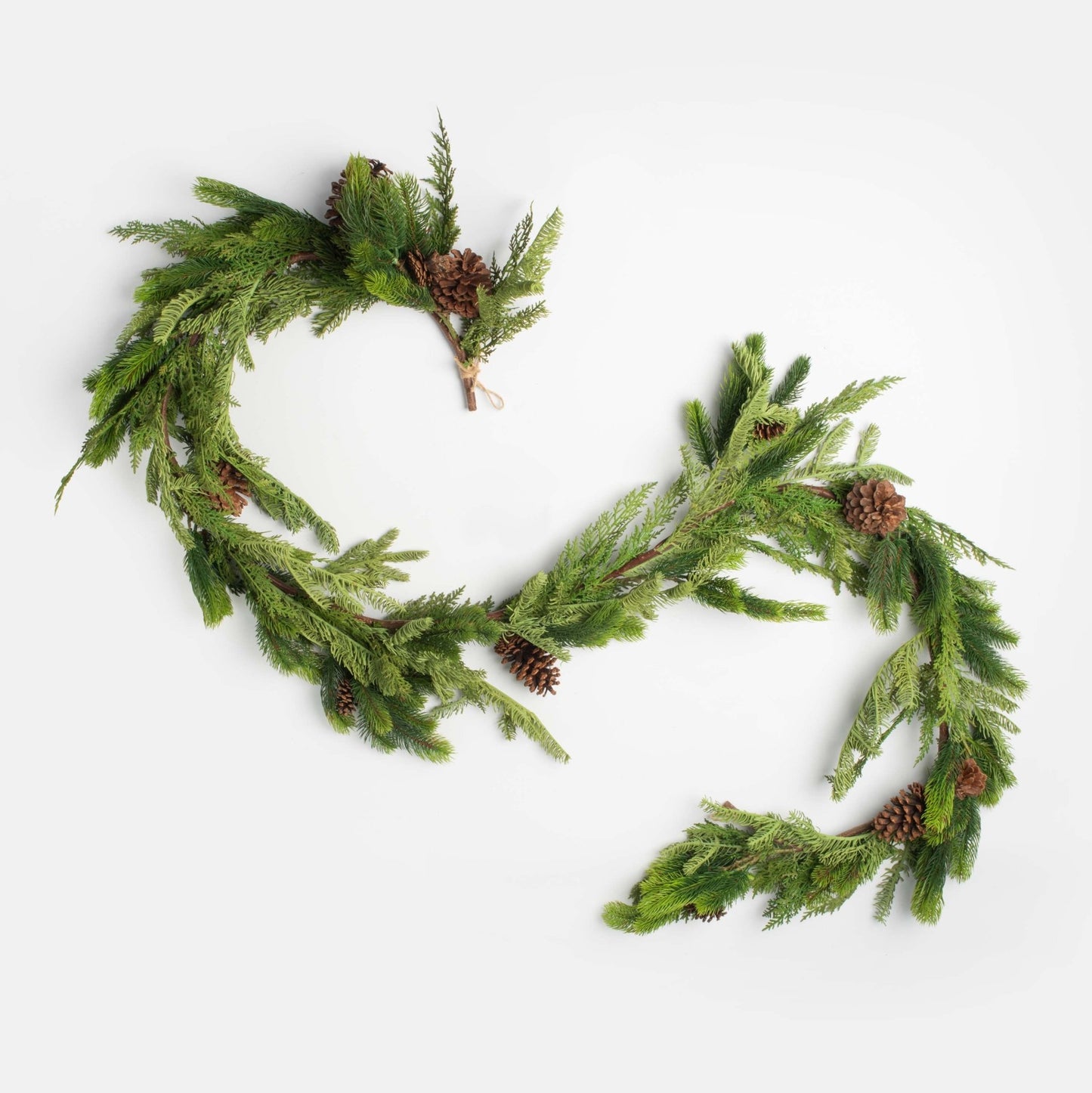 decorative christmas garland with pinecones and cedar on a white backgroun