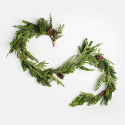 decorative christmas garland with pinecones and cedar on a white backgroun