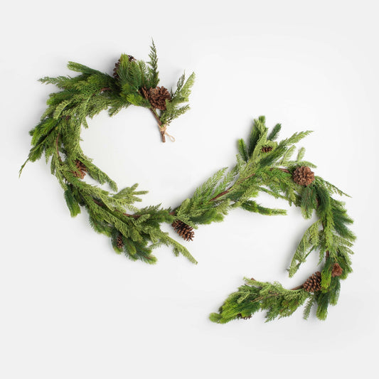 decorative christmas garland with pinecones and cedar on a white backgroun