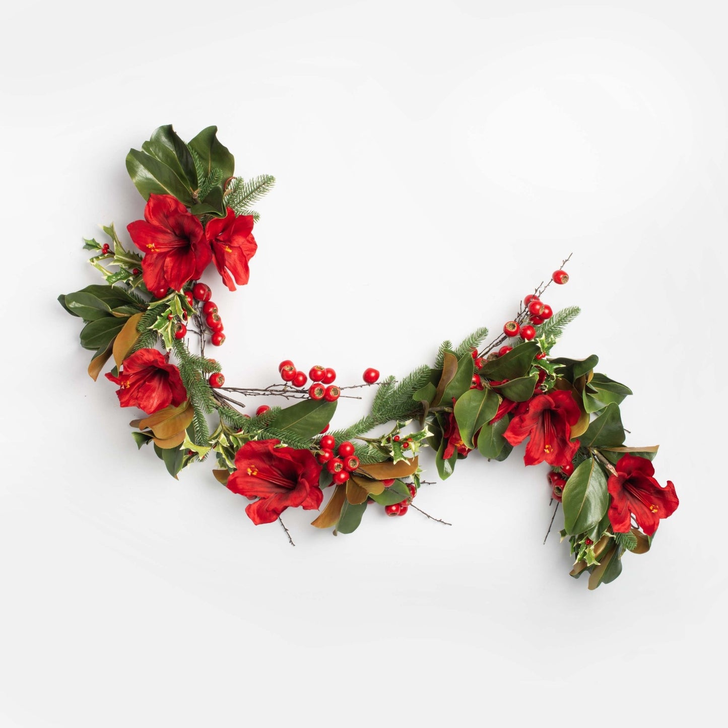 Decorative holiday wreath with red flowers and green leaves on a white background