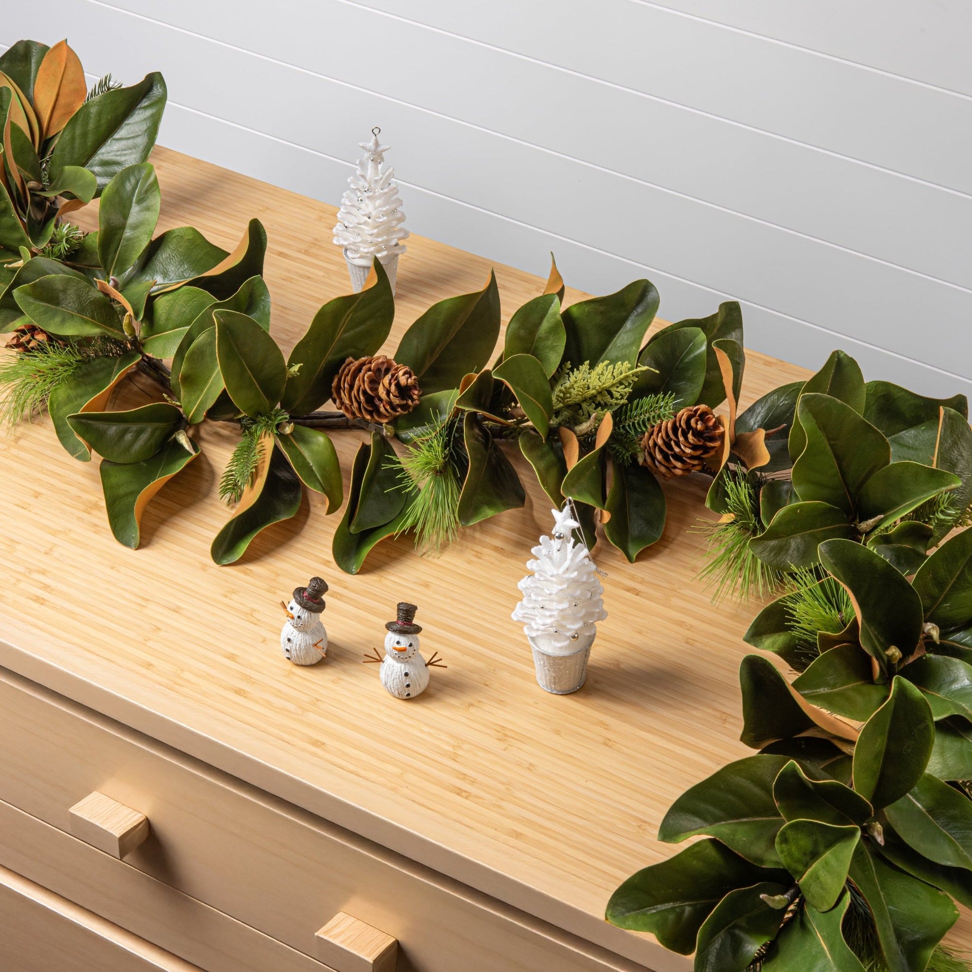 decorative magnolia garland with pinecones on a holiday background