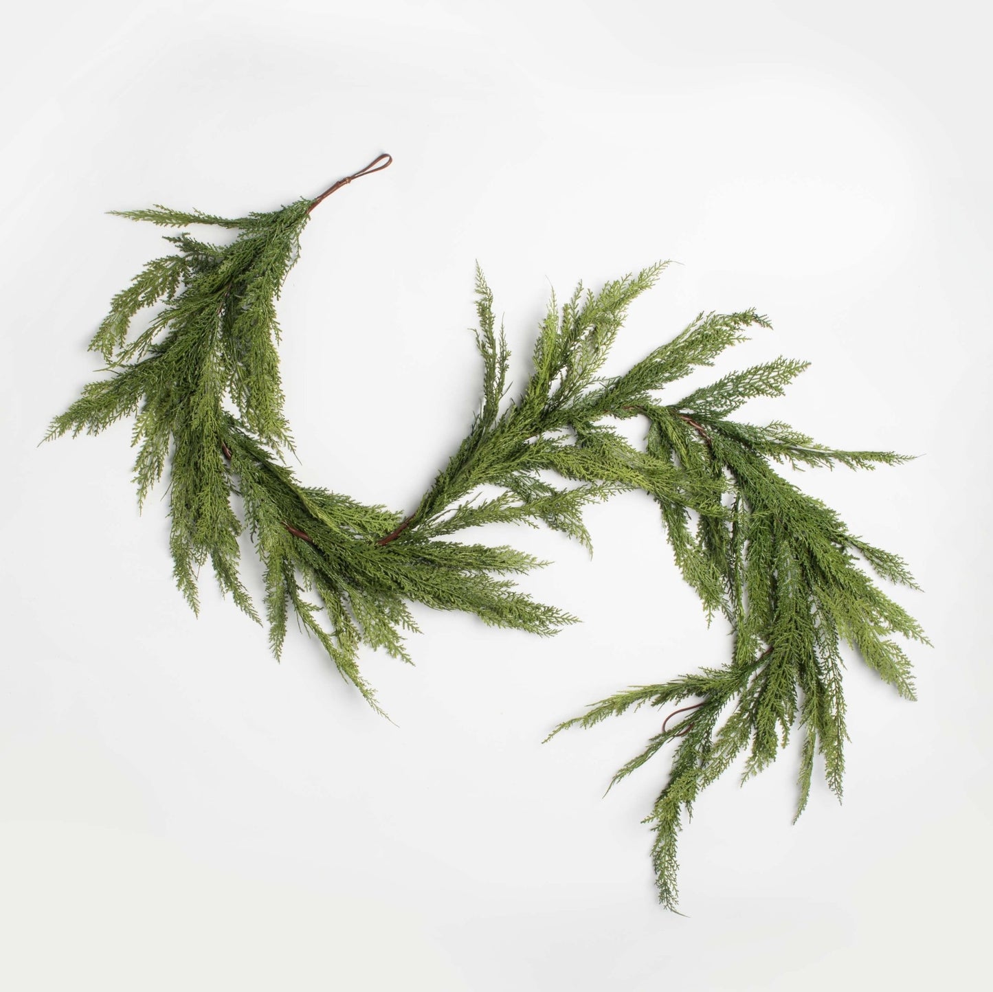 decorative holiday garland cedar and pine accents on a white background