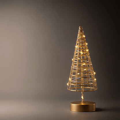 A gold wireframe cone-shaped decorative tree with warm glowing lights and a round gold base, photographed against a dark gray studio background.