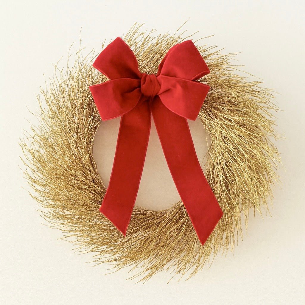 decorative gold christmas wreath with red bow on a white background