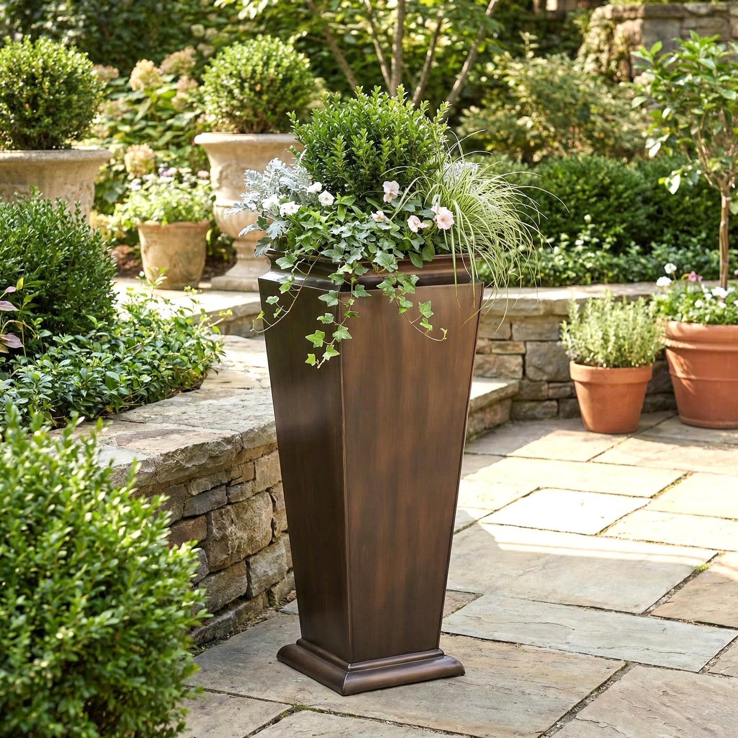 h potter tall tapered antique copper planter on stone patio with green plants