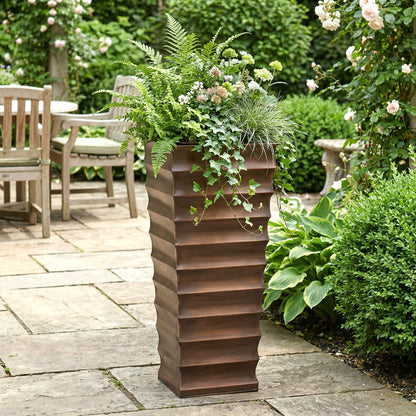 h potter tall antique copper garden planter on stone patio with green plants
