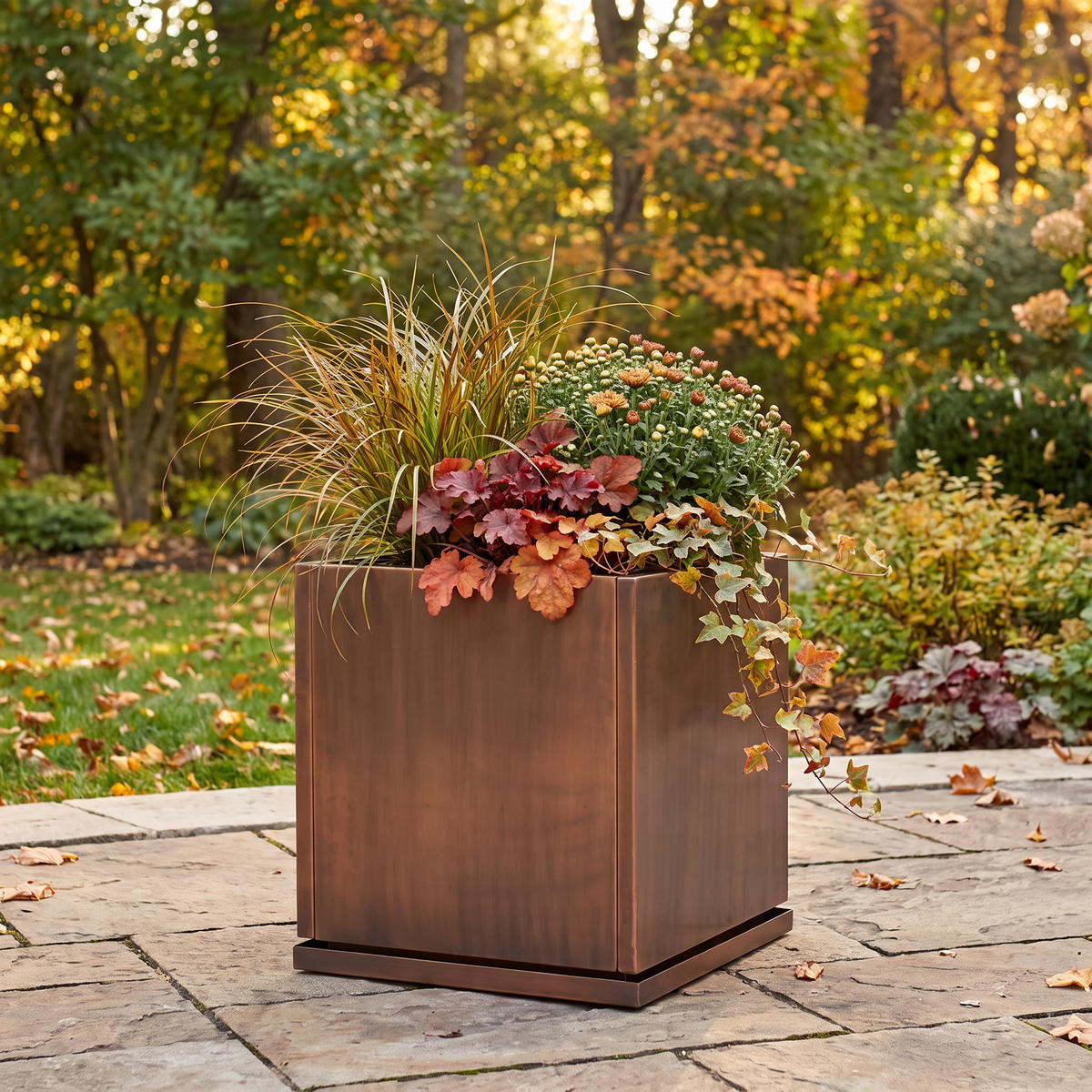 H Potter Ashbury 20-inch square antique copper planter with fall flowers on an outdoor patio