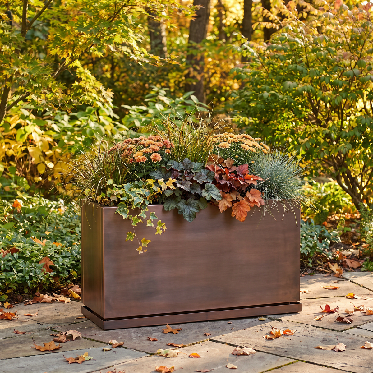 H Potter Ashbury 32-inch rectangular antique copper planter with fall flowers in an outdoor garden