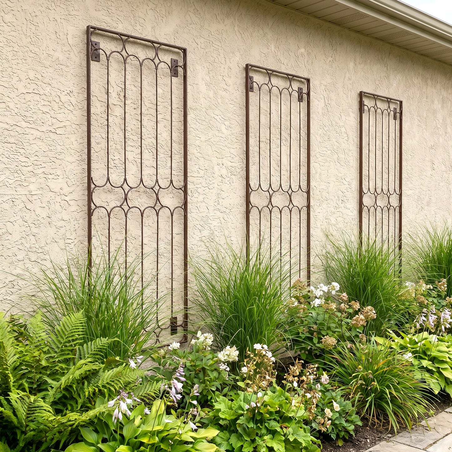 H Potter Carlisle Wall Trellis - Set of 3 on a stucco house above plants