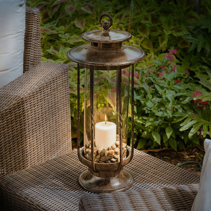H Potter cast iron hurricane lantern with clear glass and a lit candle, styled on outdoor patio furniture for garden or porch décor.