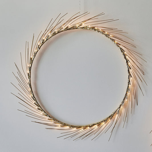 H Potter Celeste lighted wreath, large, warm LED lights on fine gold-toned spokes against a white wall