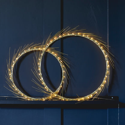 H Potter Celeste lighted wreath set, large and small rings lit on a deep navy panel wall