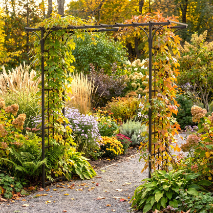 h potter brand black metal garden trellis with climbing autumn foliage, set in a lush garden pathway surrounded by colorful plants and trees.