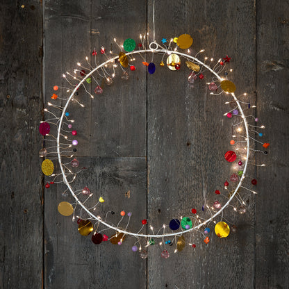 h Potter enchanted Jewel lighted wreath circle, warm fairy lights and colored glass beads on weathered grey barn wood