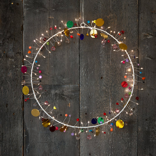 h Potter enchanted Jewel lighted wreath circle, warm fairy lights and colored glass beads on weathered grey barn wood
