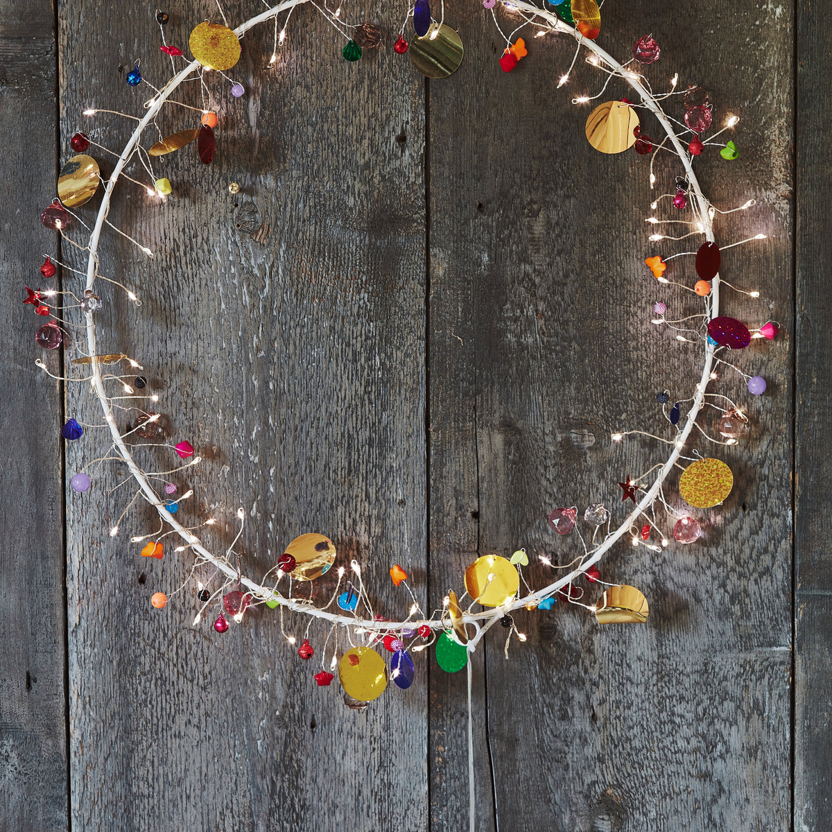 Detail of the Enchanted Jewel wreath's wire sprays, tiny warm LEDs beside red, blue and gold beads