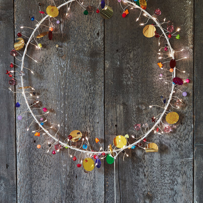 Detail of the Enchanted Jewel wreath's wire sprays, tiny warm LEDs beside red, blue and gold beads