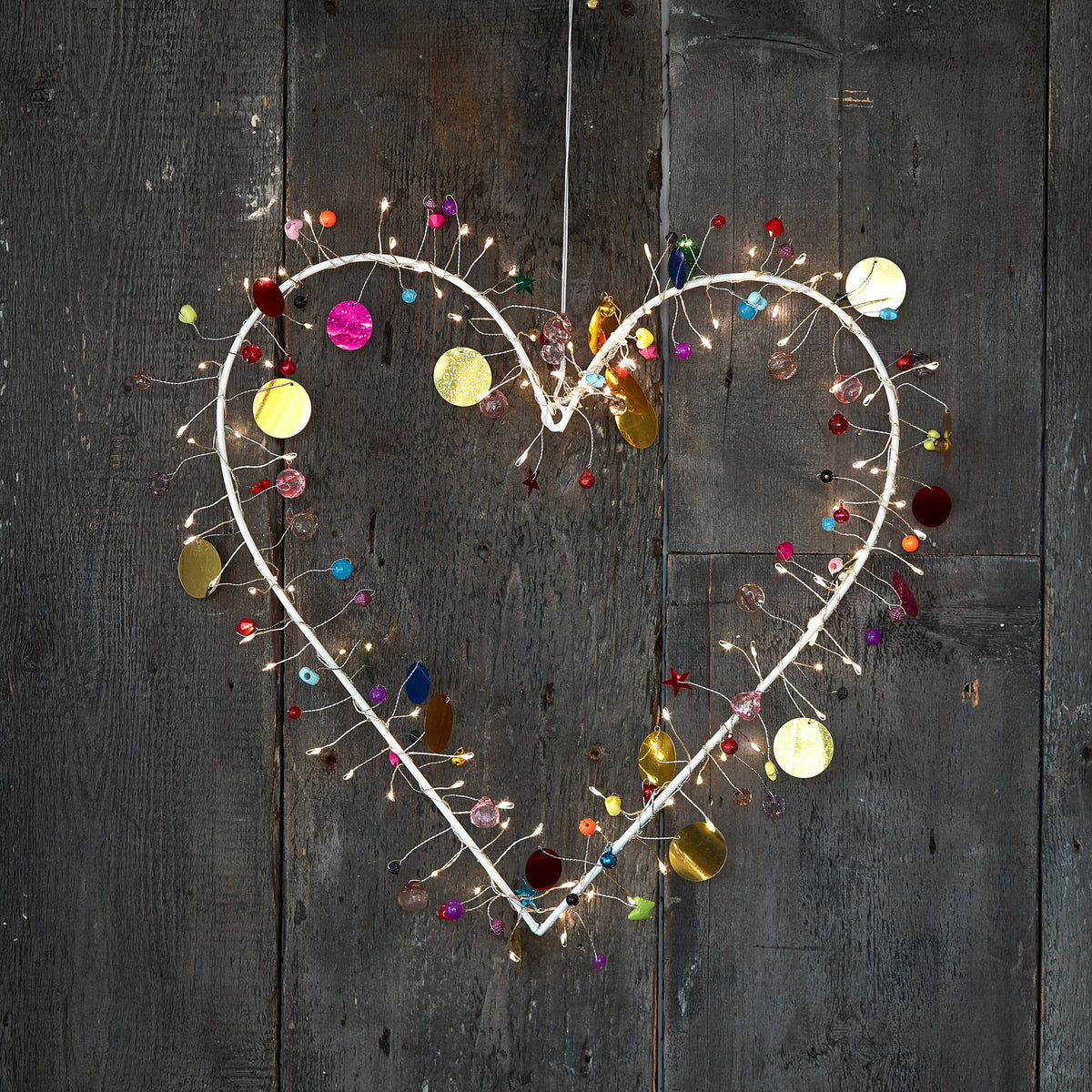 H Potter enchanted Jewel lighted heart wreath, lit with warm fairy lights and hung on rustic grey barn wood
