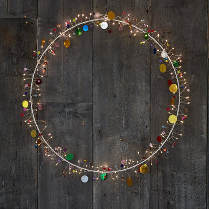 Detail of the Enchanted Jewel wreath's wire sprays, tiny warm LEDs beside red, blue and gold beads