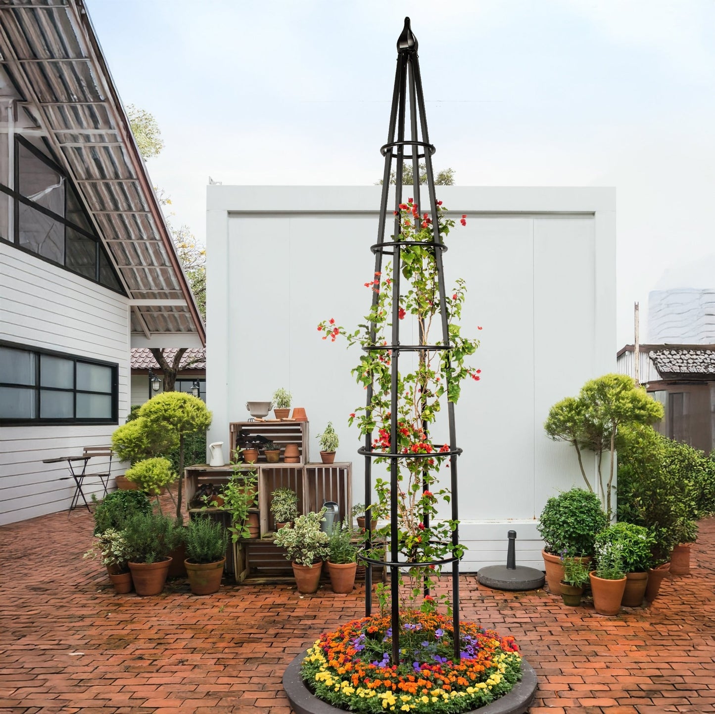 H Potter estate 10 foot black metal garden obelisk trellis installed in large backyard landscape setting