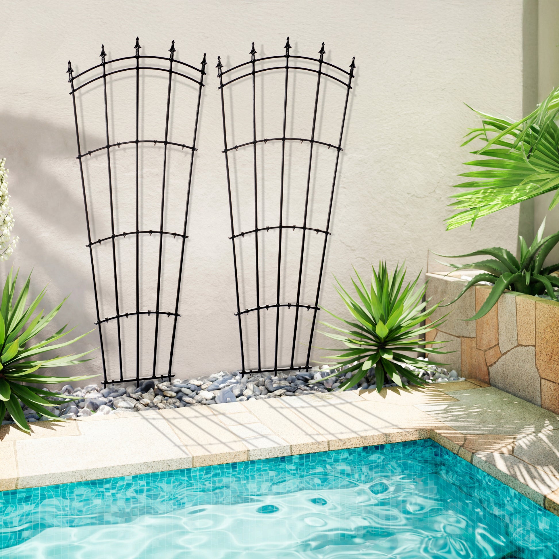 Black metal trellis by a pool with plants around
