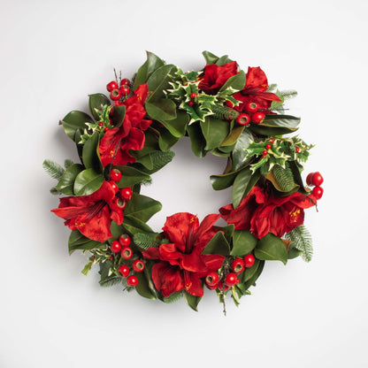 Decorative wreath with red flowers and green leaves on a white background