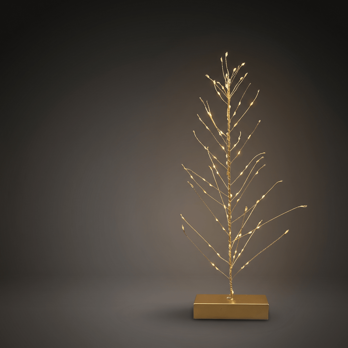 h potter gold wire tree light with small warm white LED bulbs on a rectangular gold base, photographed against a dark gray studio background.